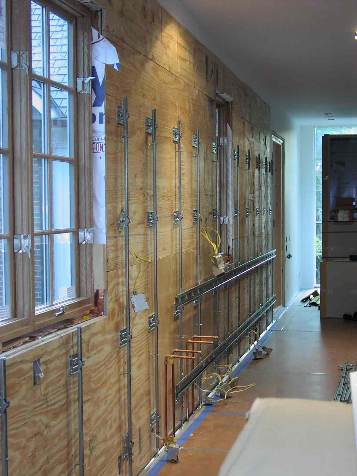 Cabinet suspension grid fastened to over framed wall.